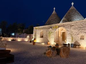 a stone building with turrets at night at Trulli Fichi Luxury Trullo with Private Spa and Saltwater Pool in Santa Lucia