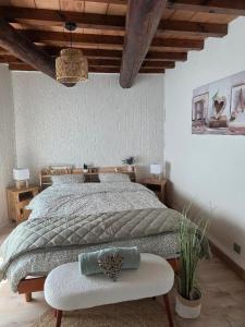 a bedroom with a large bed and a bench at La Maison Delle Spellé - Meublé de Tourisme 4 étoiles in Piolenc