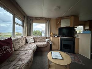 a living room with a couch and a table at Croft View Caravan Holidays in Dunvegan