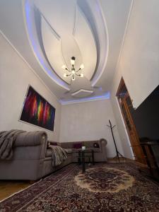a living room with a couch and a ceiling at The sweet room in Ganja