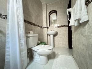 a bathroom with a toilet and a sink and a mirror at Casa Delfin in Playa del Carmen +36 photos