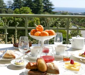 a table with a plate of food and a bowl of oranges at Château de Valmy - Chambres d'hôtes in Argelès-sur-Mer