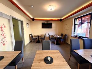 a restaurant with tables and chairs and a tv at L&L Skaters Home in Langenlipsdorf