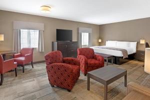 a hotel room with a bed and chairs at Best Western Colonel Butler Inn in Niagara-on-the-Lake