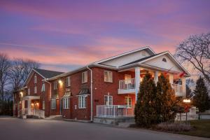 a large brick house with a sunset in the background at Best Western Colonel Butler Inn in Niagara-on-the-Lake