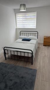 a bedroom with a bed with a window and a rug at Two-bedroom house with a workspace in Basildon in Nevendon