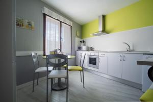 a kitchen with a table and chairs in a room at Acogedora casa histórica en Segovia by CABANA Rentals in La Lastrilla