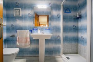 a blue tiled bathroom with a sink and a toilet at Acogedora casa histórica en Segovia by CABANA Rentals in La Lastrilla +14 photos