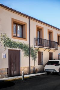 a white car parked in front of a building at Acogedora casa histórica en Segovia by CABANA Rentals in La Lastrilla