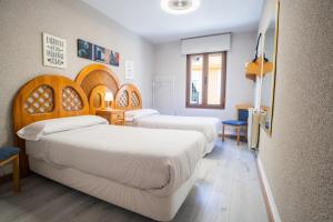 a hotel room with two beds and a mirror at Acogedora casa histórica en Segovia by CABANA Rentals in La Lastrilla