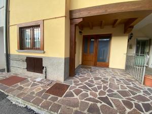 a front door of a house with a stone floor at Casa Elisa in Onore +4 photos
