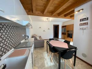 a kitchen and living room with a table and a couch at Casa Elisa in Onore