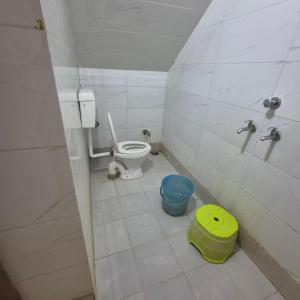 a small bathroom with a toilet and buckets in it at Sky Desert Safari With Swimming Pool in Jaisalmer