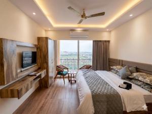 a hotel room with a large bed and a television at The Rudraya - Suites in Greater Noida