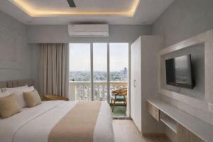 a hotel room with a bed and a large window at The Rudraya - Suites in Greater Noida