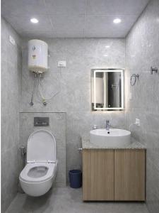 a bathroom with a toilet and a sink at The Rudraya - Suites in Greater Noida +19 photos