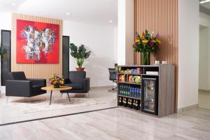 a lobby with two chairs and a drink cooler at Hotel Regency Boutique La Feria in Bogotá