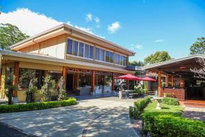 ein Gebäude mit roten Regenschirmen davor in der Unterkunft Hotel Robledal in Alajuela