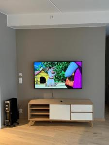 a living room with a flat screen tv on a wall at Oslo Gateway Apartment in Lørenskog in Lorenskog