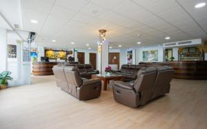 a waiting room with leather chairs and a barber shop at Hotel El Tajo & SPA in Ronda