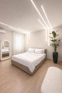 a white bedroom with a large bed and a mirror at Villa Ikal in Modugno +28 photos