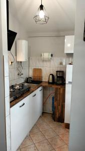 a kitchen with white cabinets and a white refrigerator at Agroturystyka U Anny in Rzepedż