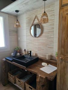 a bathroom with a black sink and a mirror at La Maison Delle Spellé - Meublé de Tourisme 4 étoiles in Piolenc +30 photos
