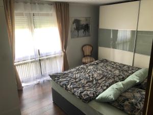 a bedroom with a bed and a window and a chair at Ferienwohnung Untersee in Öhningen