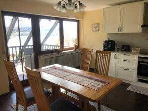 a kitchen with a table and chairs and a kitchen with a window at Ferienwohnung Untersee in Öhningen