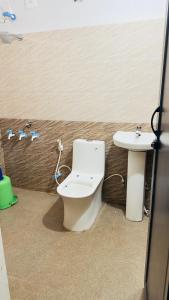 a bathroom with a toilet and a sink at Delight rooms in Mysore