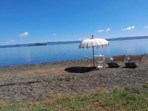a table and chairs under an umbrella on a beach at casamiacasatua in Ronciglione