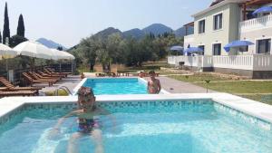 two children in a swimming pool at a resort at Golden Sun Villas in Nydri