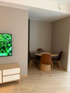 a dining room with a table and chairs and a tv at Oslo Gateway Apartment in Lørenskog in Lorenskog +7 photos