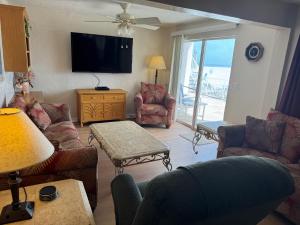 a living room with couches and a flat screen tv at Sierra Suites in Daytona Beach