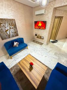 a living room with a blue couch and a fireplace at Vivienda 01 Appartement moderne au cœur de Mohammedia , Calme et Confort in Mohammedia