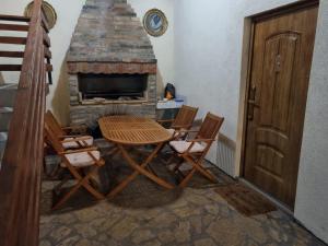 a room with a table and chairs and a fireplace at Zlatna Vila 2 in Kanjiža
