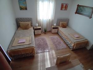 a bedroom with two beds and two rugs at Zlatna Vila 2 in Kanjiža
