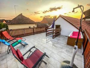 a patio with chairs and a table and a fence at Zlatna Vila 2 in Kanjiža