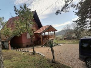 a large red house with a gambrel roof at Suncani breg in Ljig
