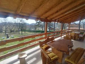a large porch with a table and chairs and a field at Suncani breg in Ljig +2 photos