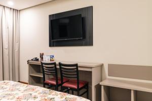 a hotel room with two chairs and a desk with a television at Hotel Dan Inn Uberlandia By Nacional Inn in Uberlândia +41 photos
