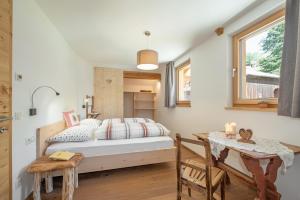 a bedroom with a bed and a desk and a table at Ferienbauernhof Wieserhof in Völs am Schlern