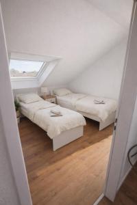 a attic room with three beds and a window at Appartment Okarben in Karben