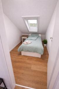 a attic bedroom with a bed and a window at Appartment Okarben in Karben