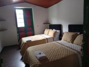 a room with two beds and a red door at Posada La Casona in El Cocuy