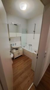 a bathroom with a toilet and a sink and a tub at Appartment Okarben in Karben