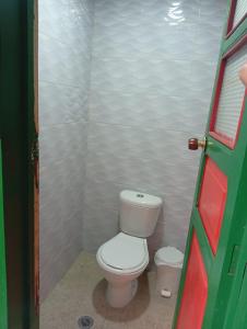 a small bathroom with a toilet in a stall at Posada La Casona in El Cocuy
