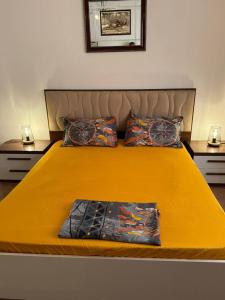 a large yellow bed with two pillows on it at Villa Oasis Ain El Turk in Aïn El Turk