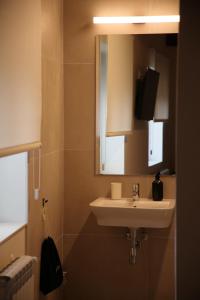 a bathroom with a sink and a mirror and a television at Casa Carmina Hostel in Muros de Nalón +118 photos