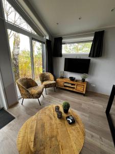 a living room with a coffee table and a television at Veluwe Retreat Inn Otterlo! in Otterlo